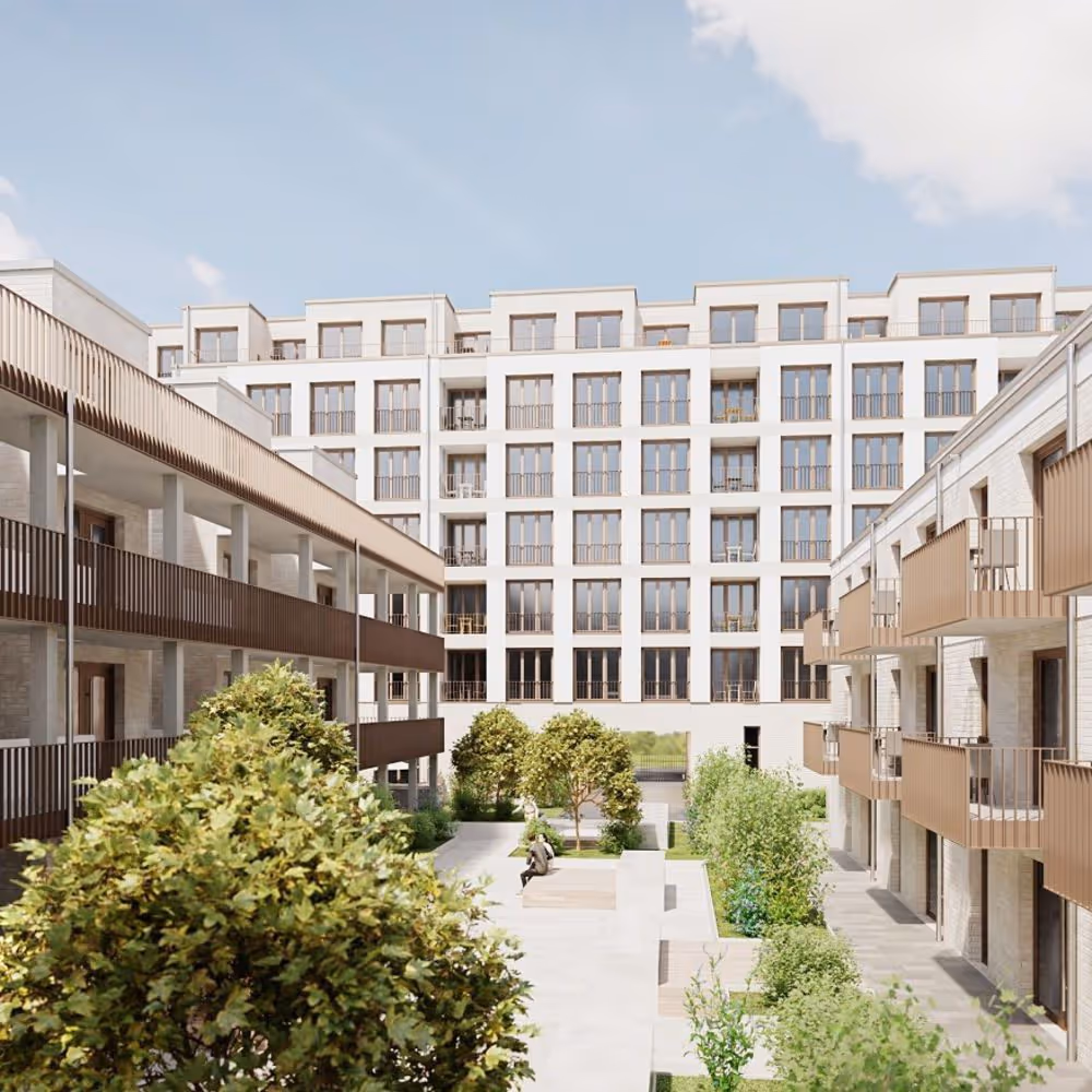 Innenhof zwischen mehreren modernen Gebäuden mit Bäumen und 2 Menschen auf der Bank.