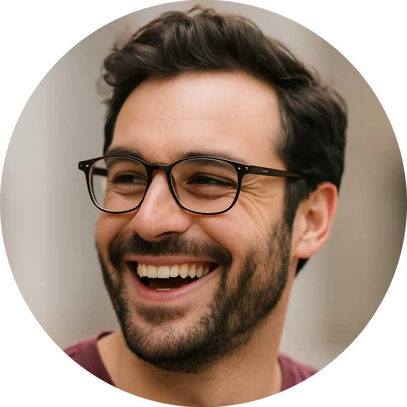 Smiling man with dark hair, beard, and glasses wearing a maroon shirt.