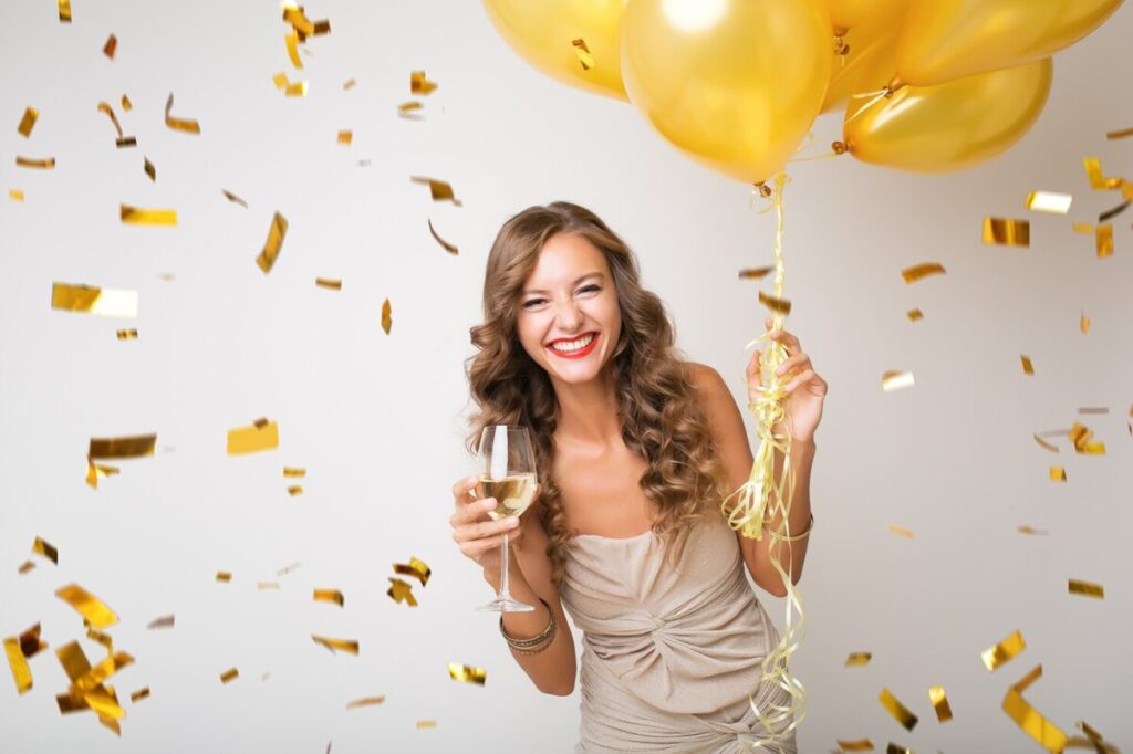 brunette woman with yellow balloons and big smile