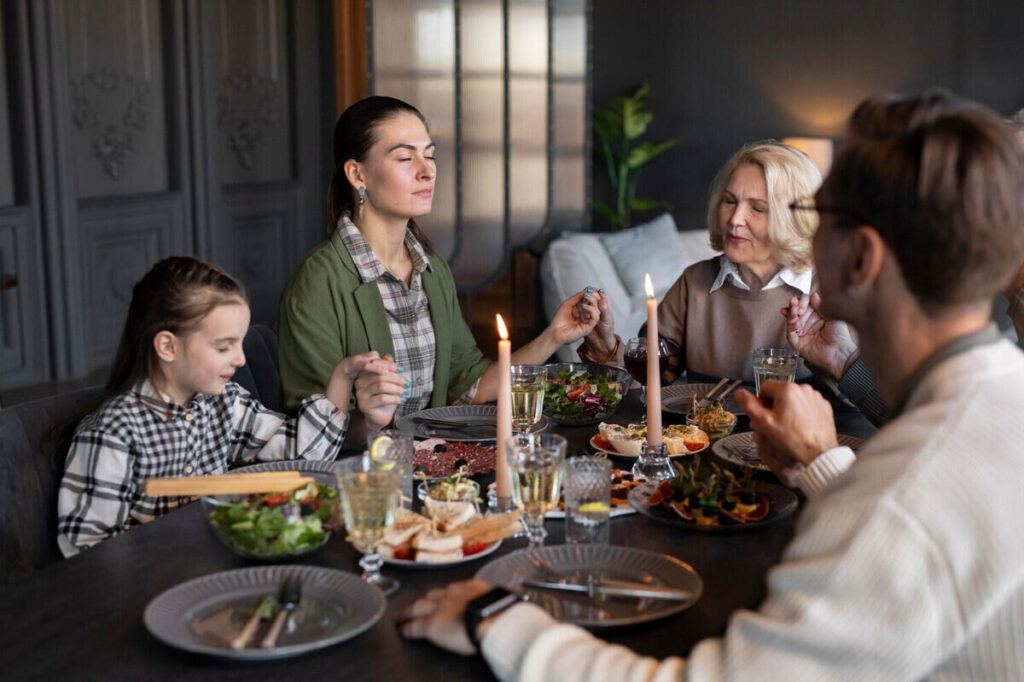 family praying at dinner before eating