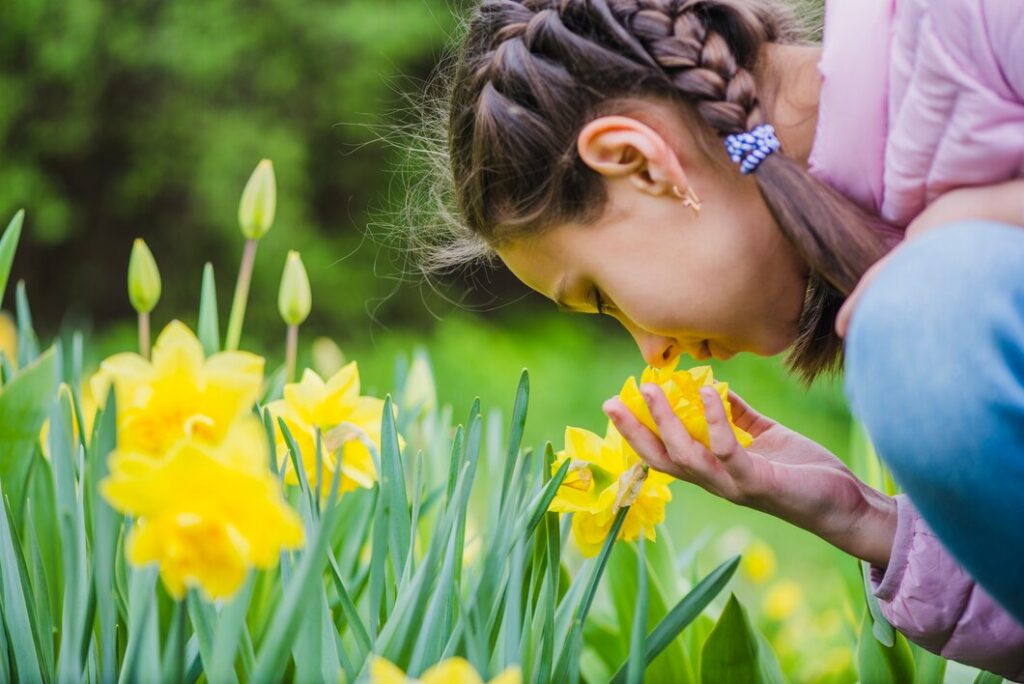 young girl smelling flowers in the spring