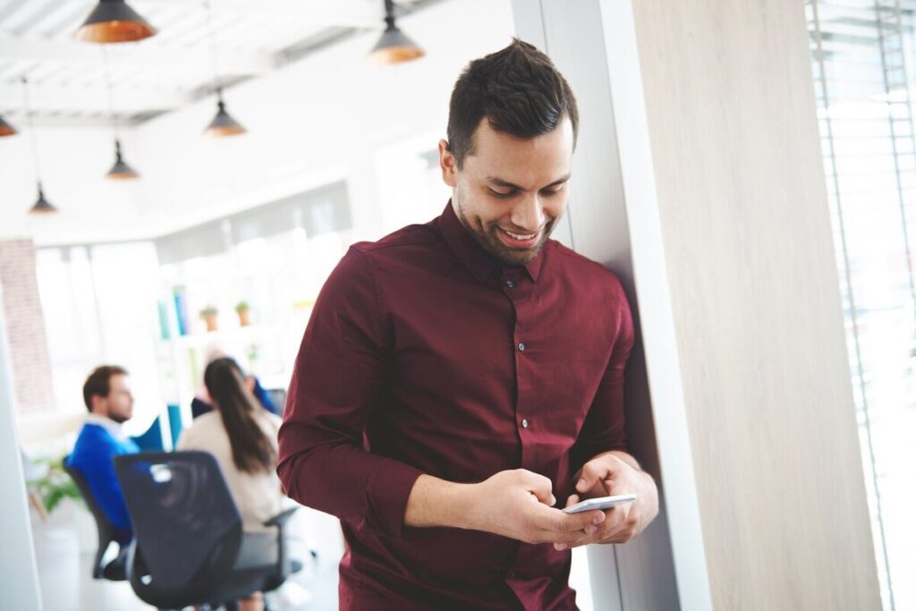 A man smilling while writing captions about new job
