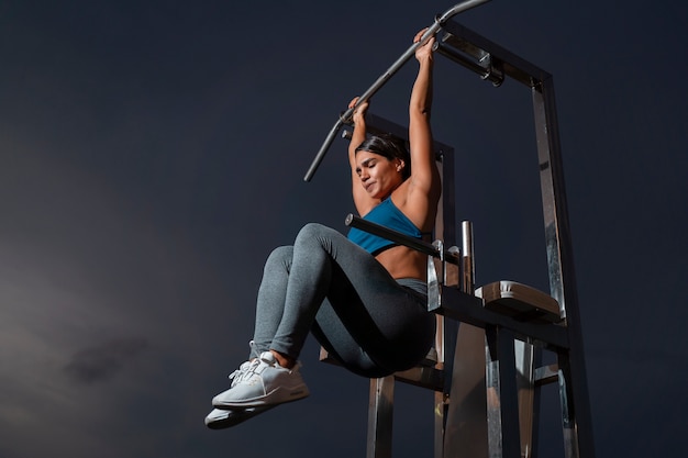 a woman doing a pull up excercise for fitness competition