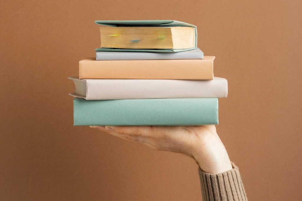 A stack of books on a hand