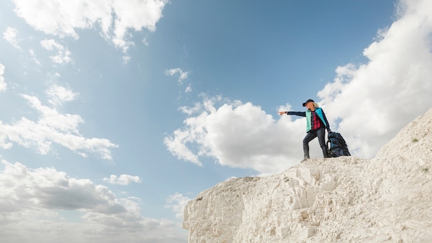 A woman pointing foward on a hill on motivational hike for instagram