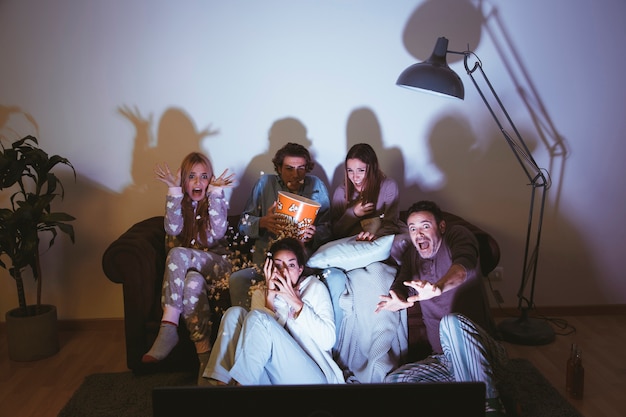 Group of friends on the sofa with blankets
