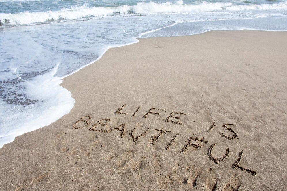 writing captions on the sand on a beach day