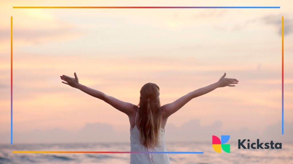 Inspired woman with open arms by ocean