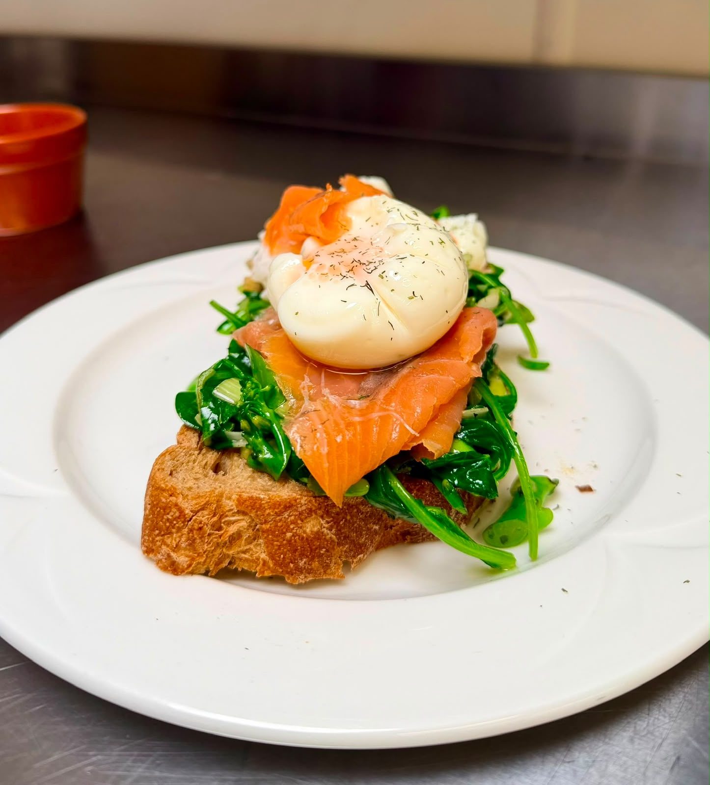 Smoked salmon with a poached egg and sauteed seasonal greens on sourdough toast at The Barn Kitchen