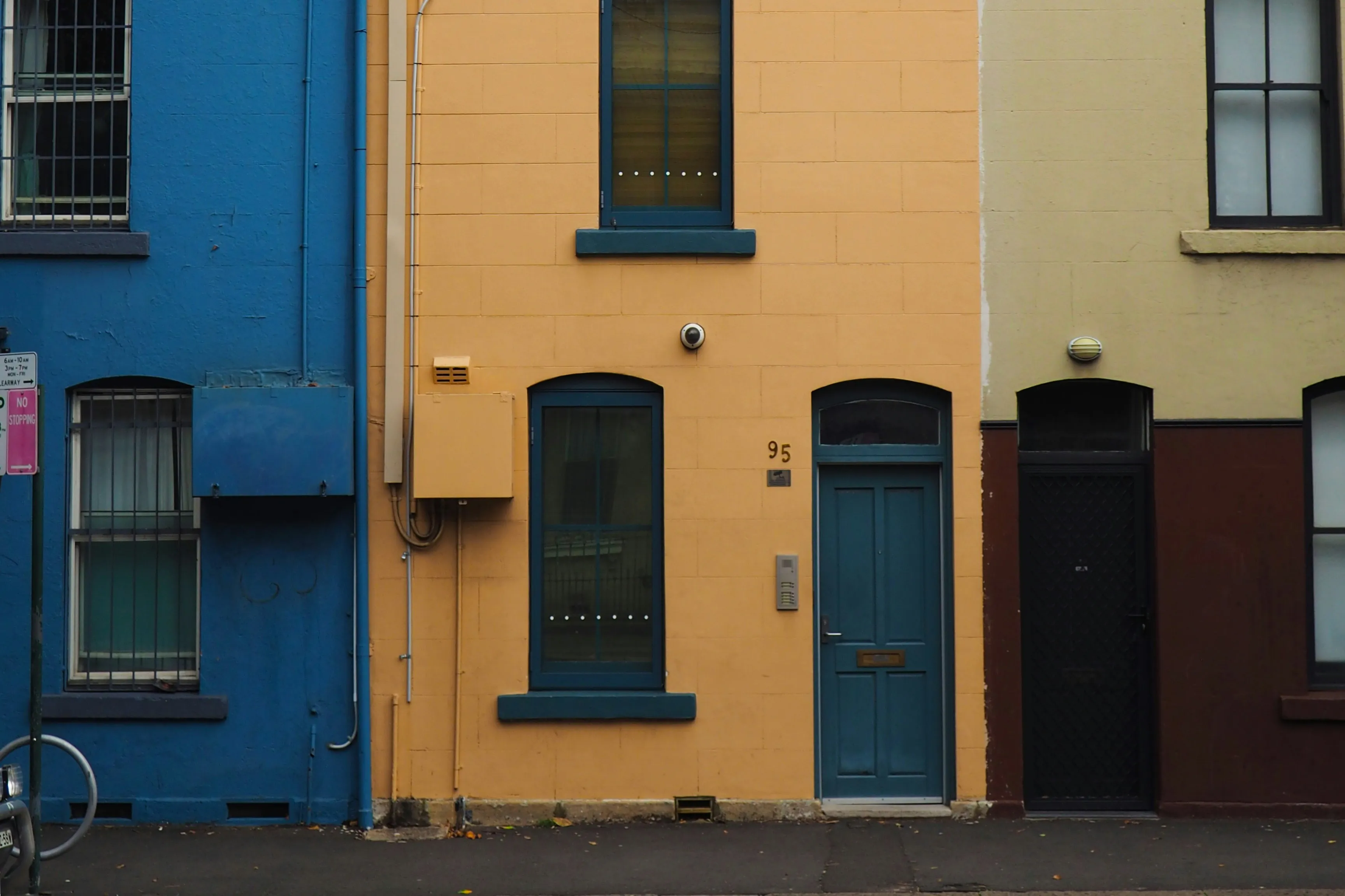 Row of colourful terrace house fronts in blue, yellow and cream
