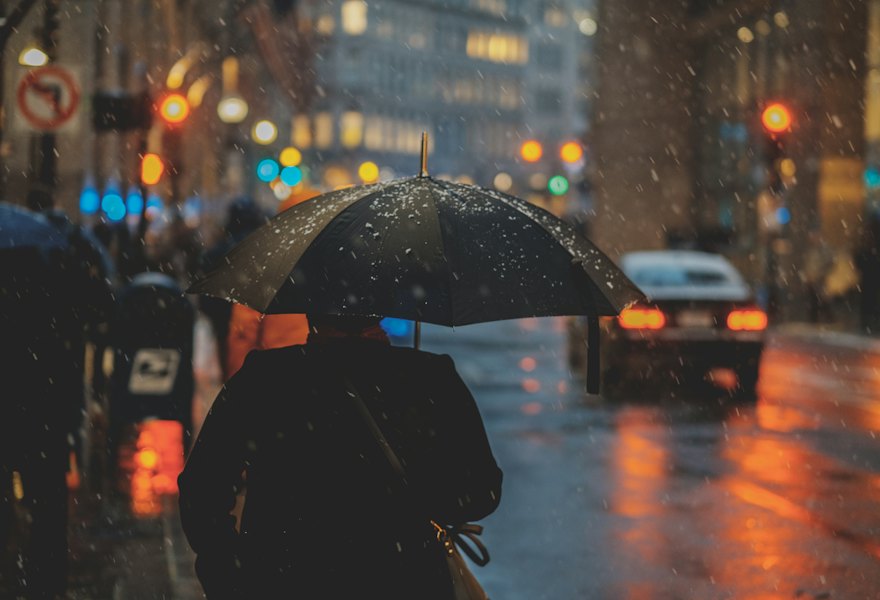 A person with an umbrella on a rainy city street