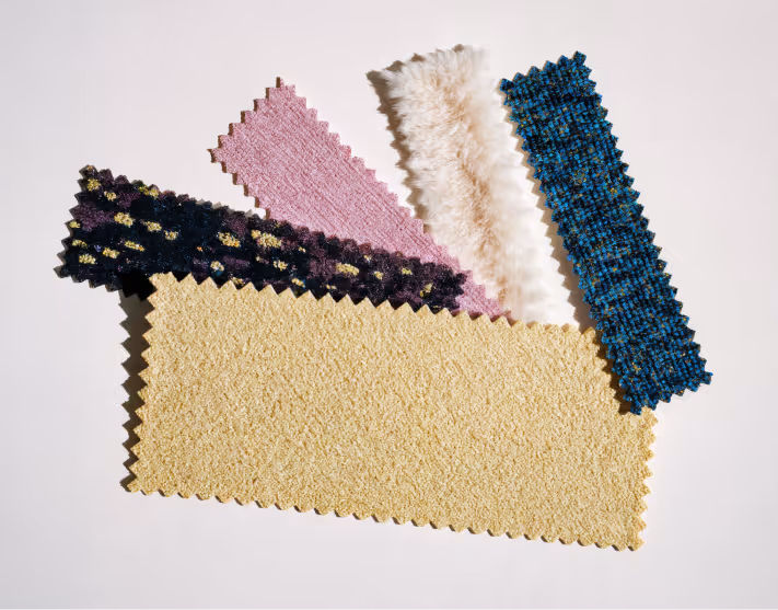 Colorful fabric swatches for sustainable fashion production — boucle, faux fur, and textured weaves