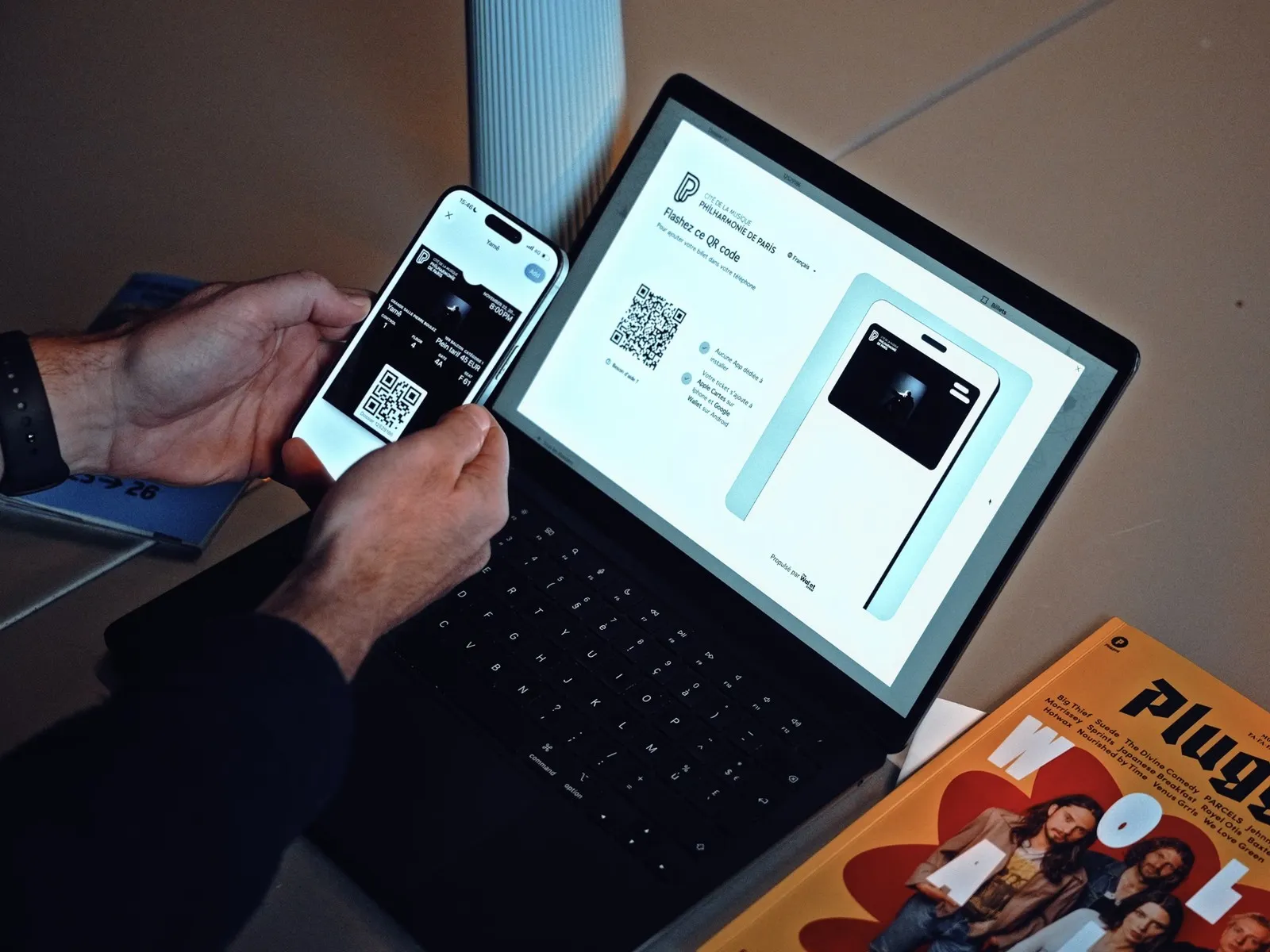 Client ajoutant son billet de la Philharmonie de Paris à son téléphone en flashant le QR code affiché sur ordinateur