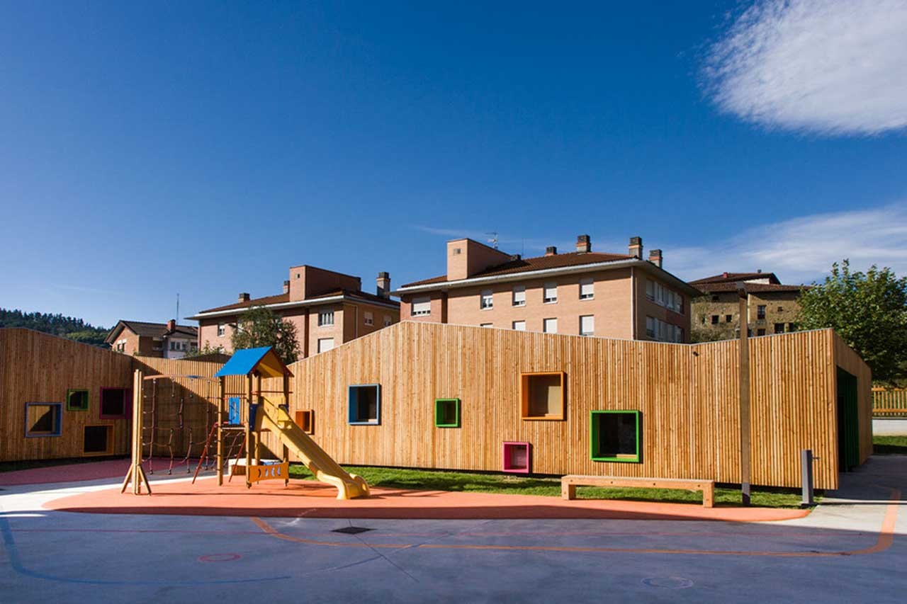 Timber-clad nursery building with a playground and slide