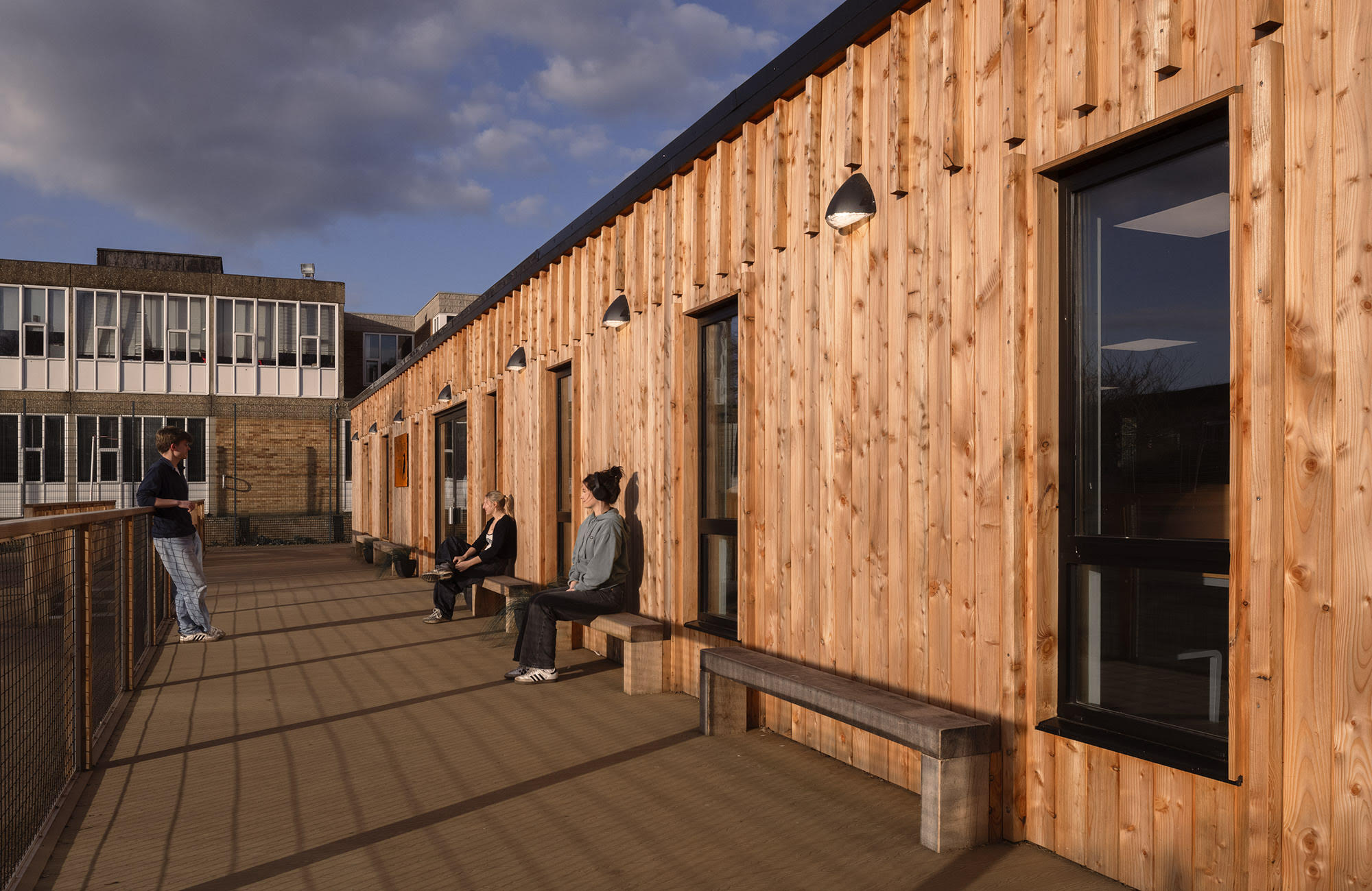 Students relaxing on the timber decking alongside St Benedict's sixth form building
