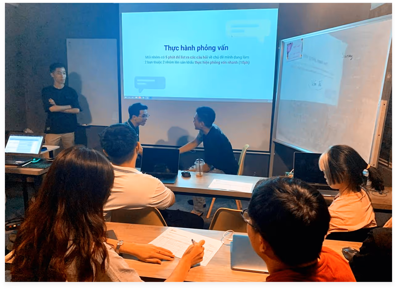 a group of people in a room with a projector screen