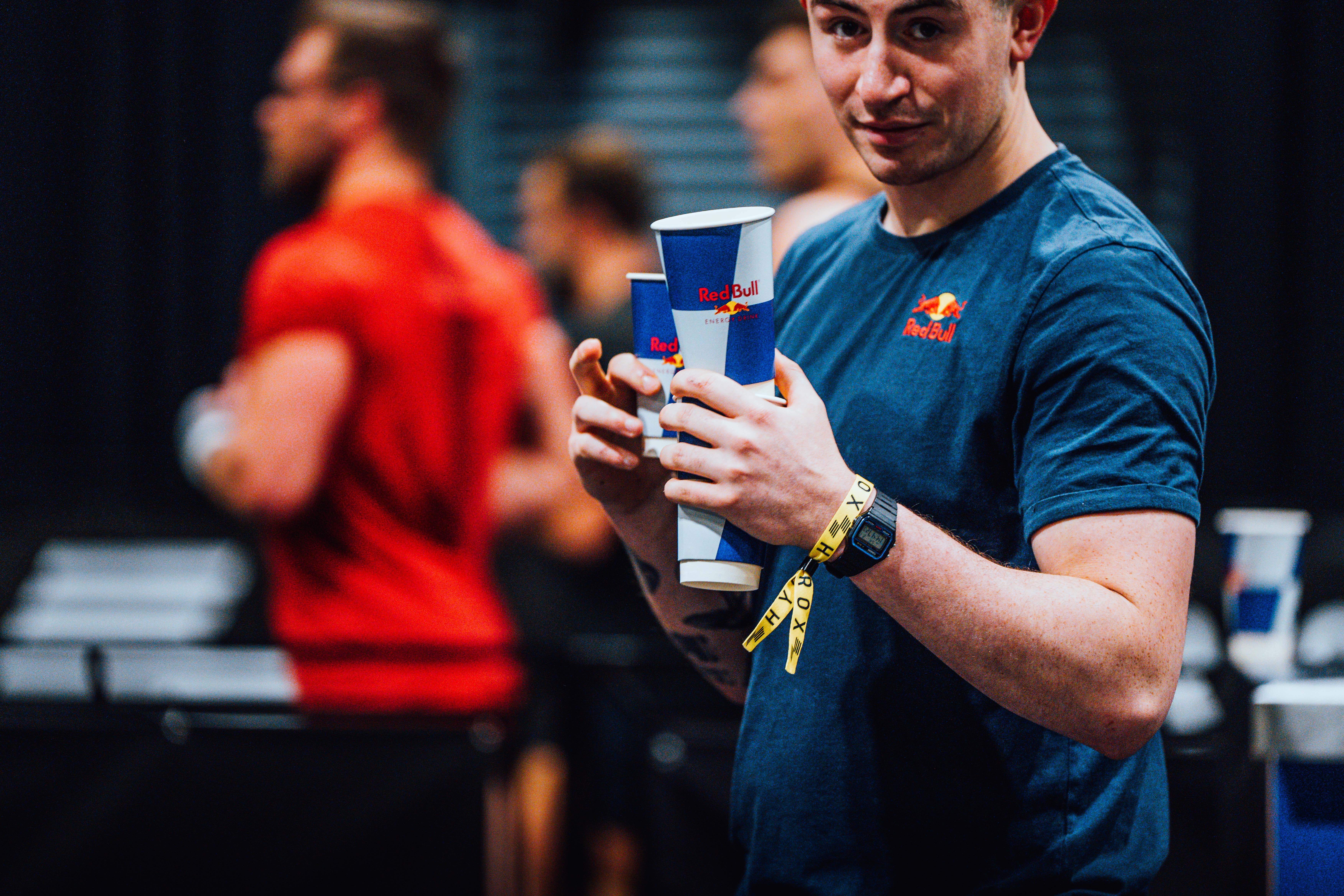 HYROX participant carrying cups of Redbull