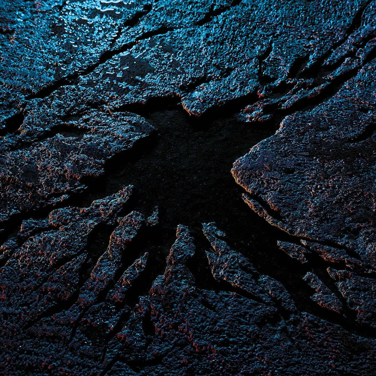 Personne en tenue rouge marchant sur un paysage enneigé avec un objet orange allongé à côté.