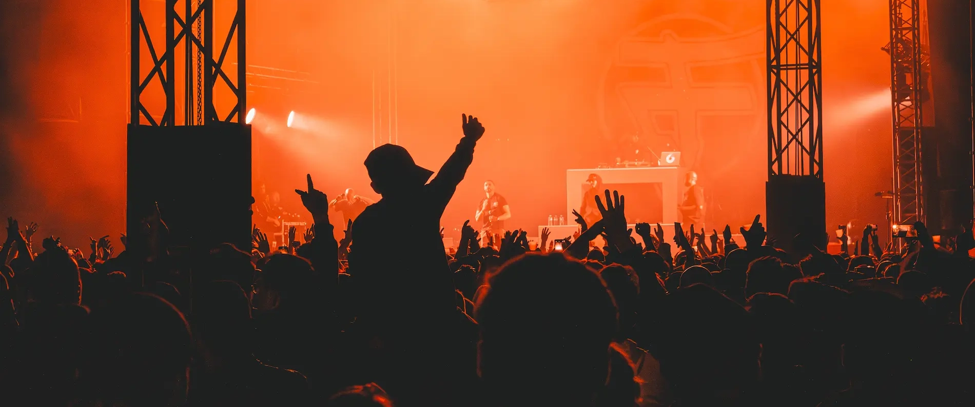 Chanteuse sur scène éclairée par plusieurs projecteurs, devant une foule nombreuse lors d'un concert.