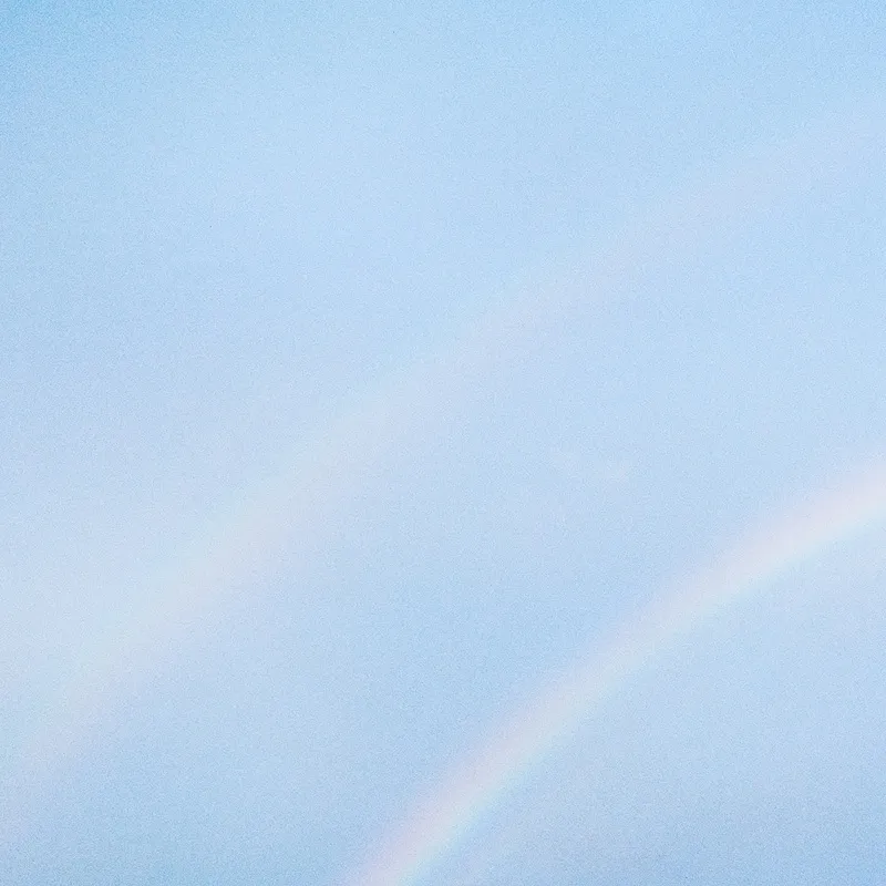 Personne en tenue rouge marchant sur un paysage enneigé avec un objet orange allongé à côté.