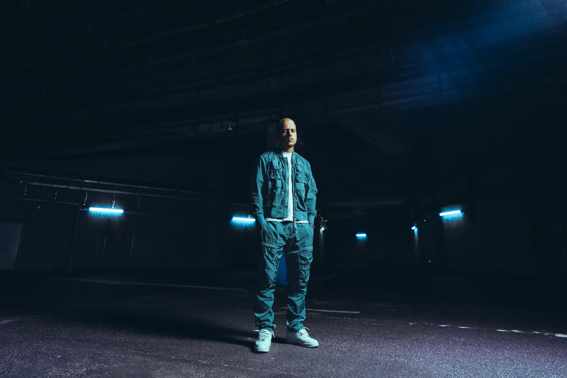 Jeune femme avec les cheveux noirs portant un maillot de football blanc du Napoli avec un fond bleu.