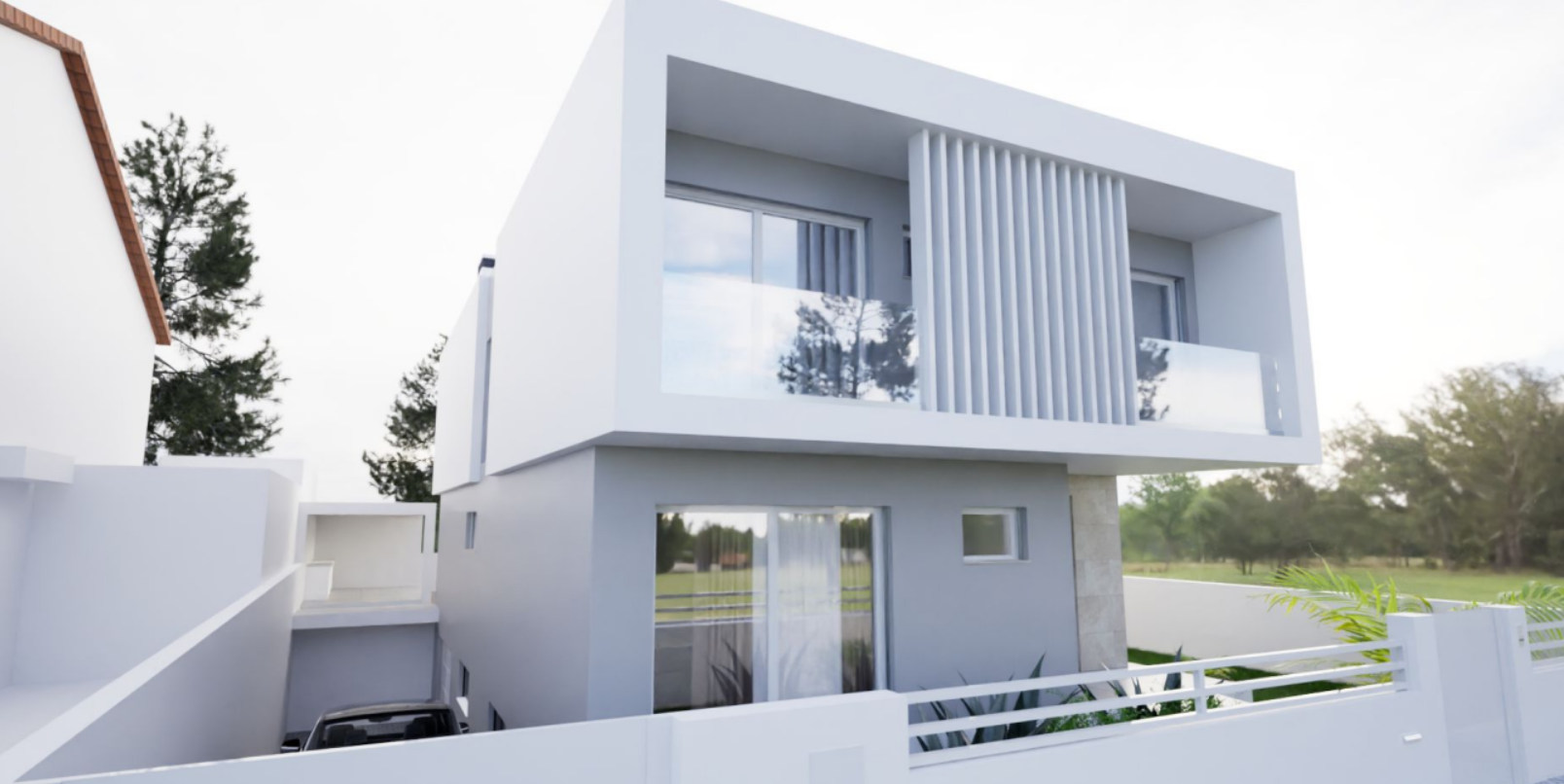 Casa moderna branca de dois andares com varanda e vidros, cerca branca e vegetação ao redor.