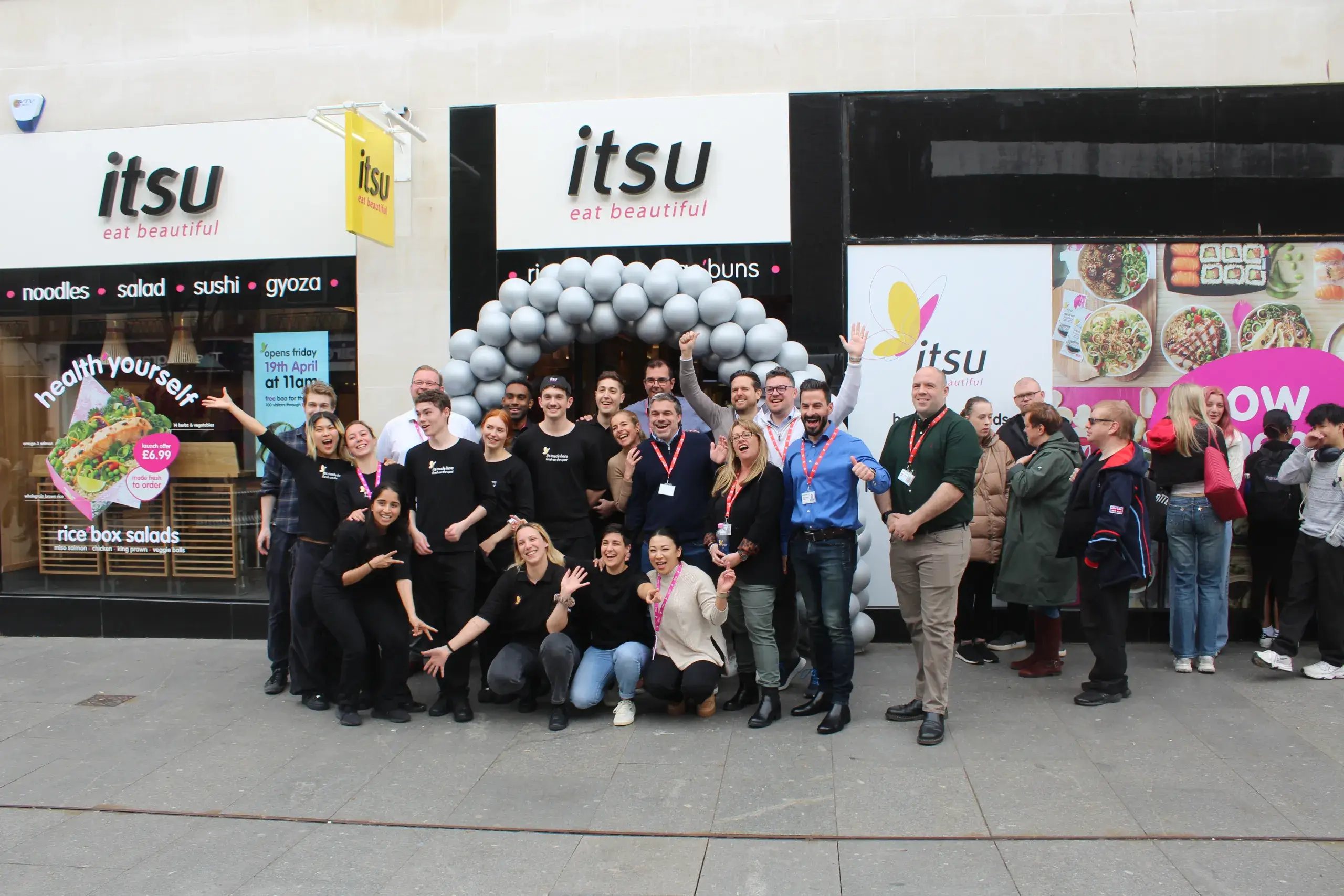 Scoffs team posing in front of newly opened Itsu storefront