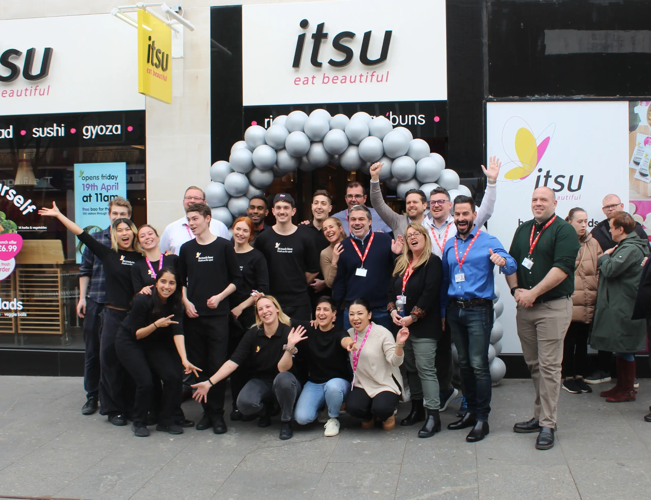 Scoffs team posing in front of newly opened Itsu storefront
