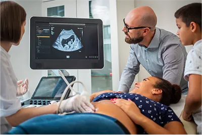 a doctor doing ultrasound of a pregannt lady accompanied by her family