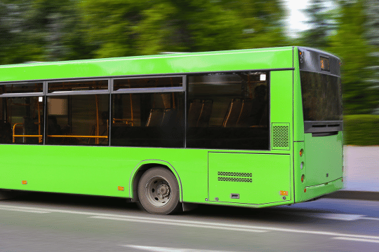 Grüner Bus, der links aus dem Bild rausfährt