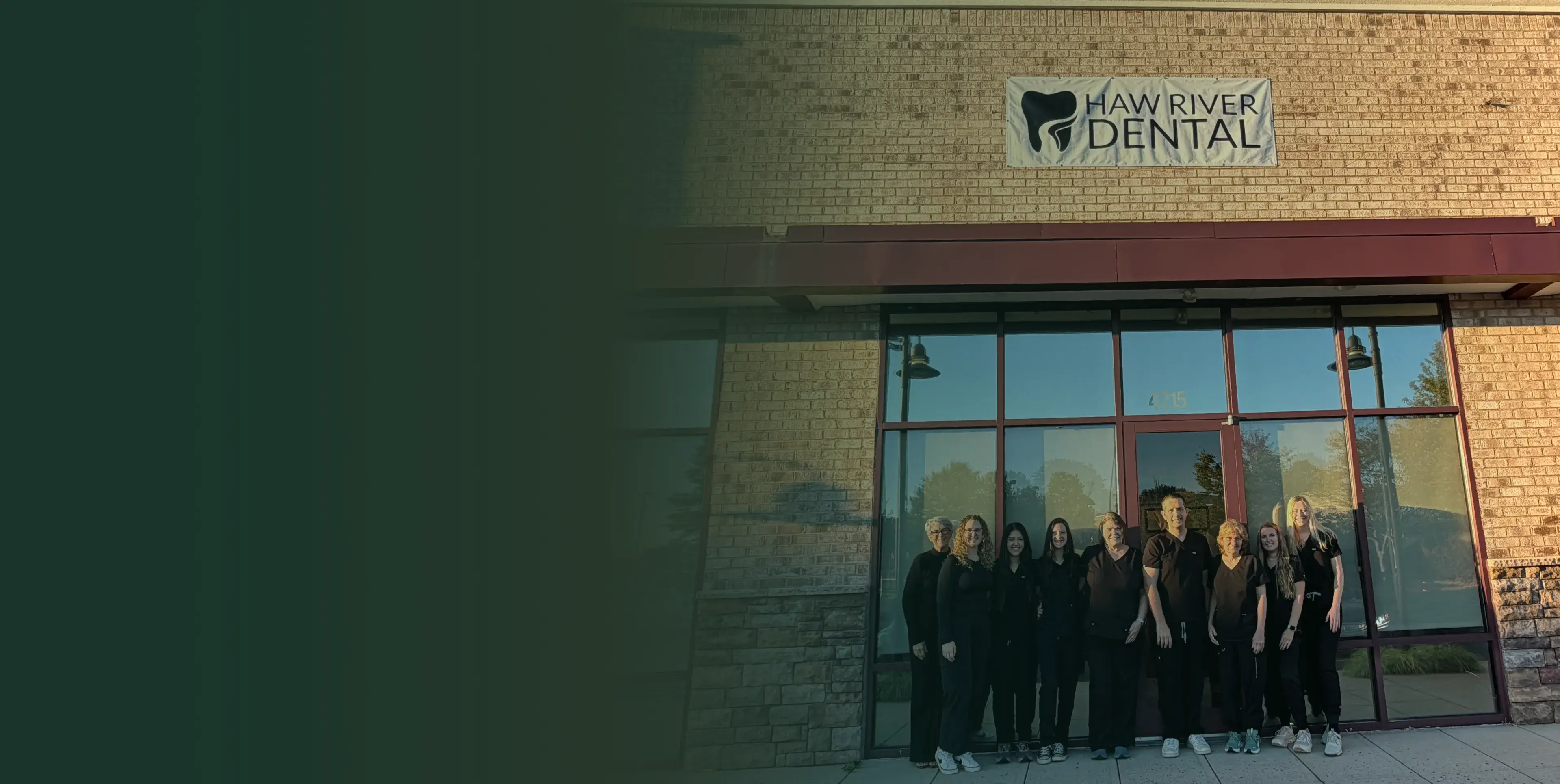 A group of people is standing in front of a dental office building.