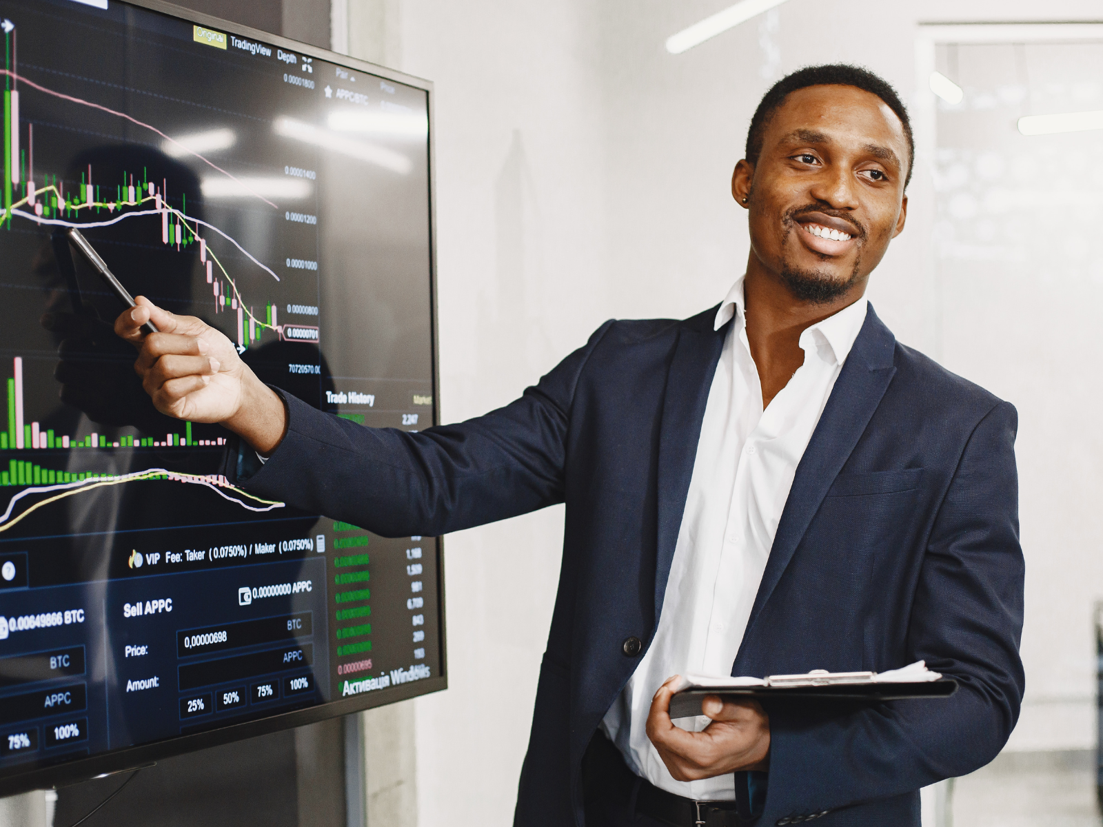 a man in a suit pointing at a screen