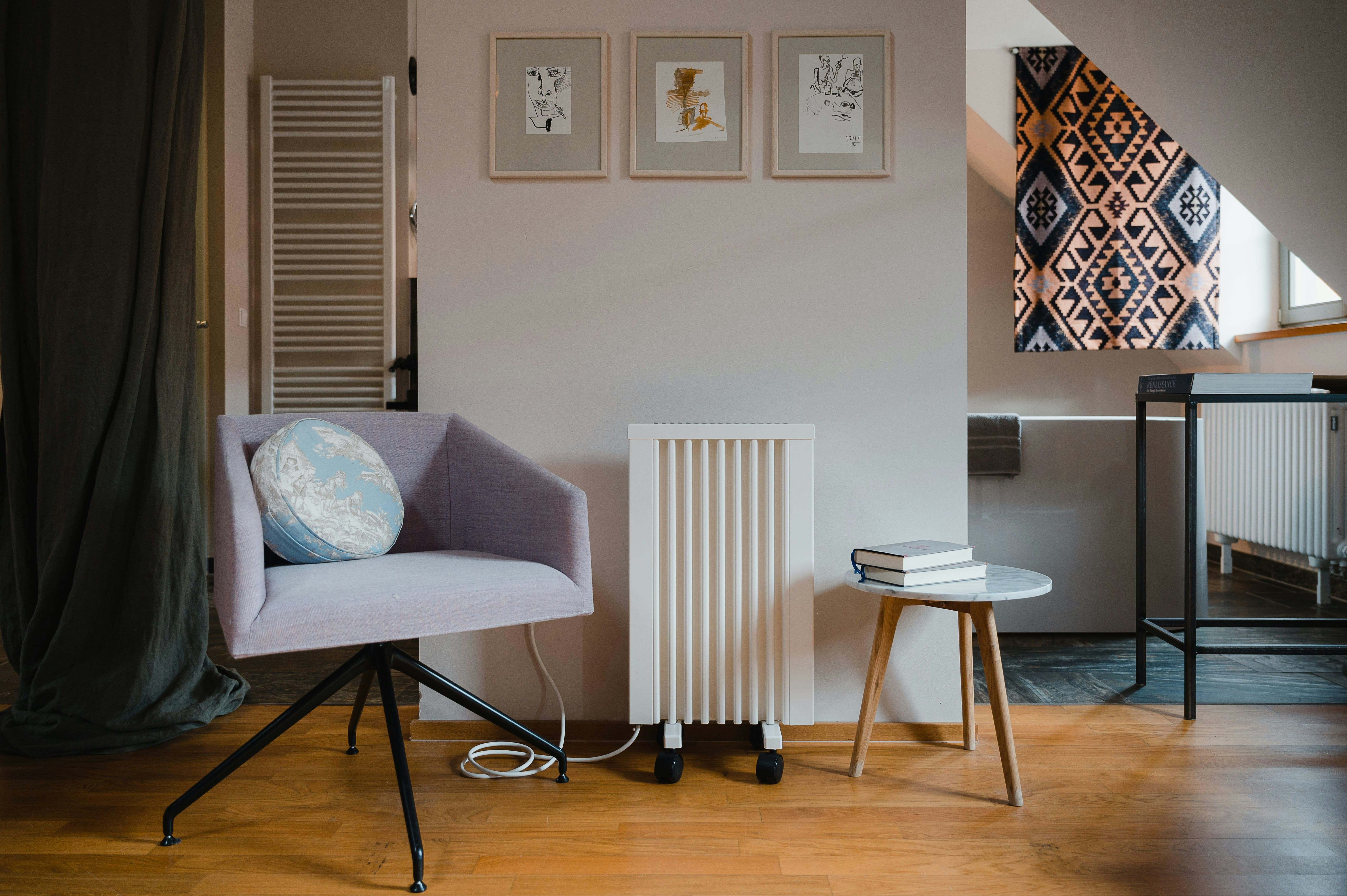 Modern living room corner with purple chair, art prints, and geometric rug