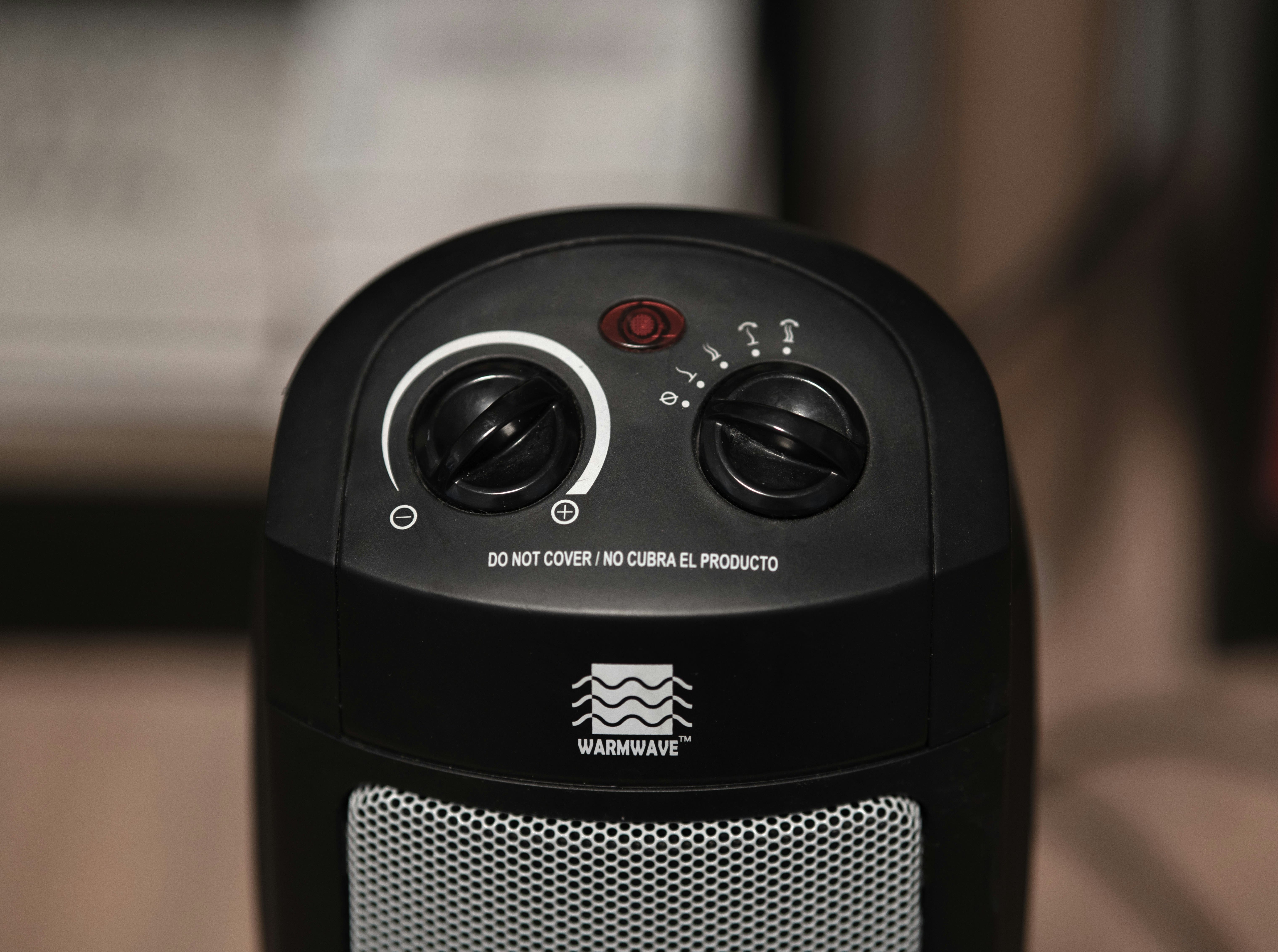 Black Warmwave ceramic space heater with control dials and safety warning