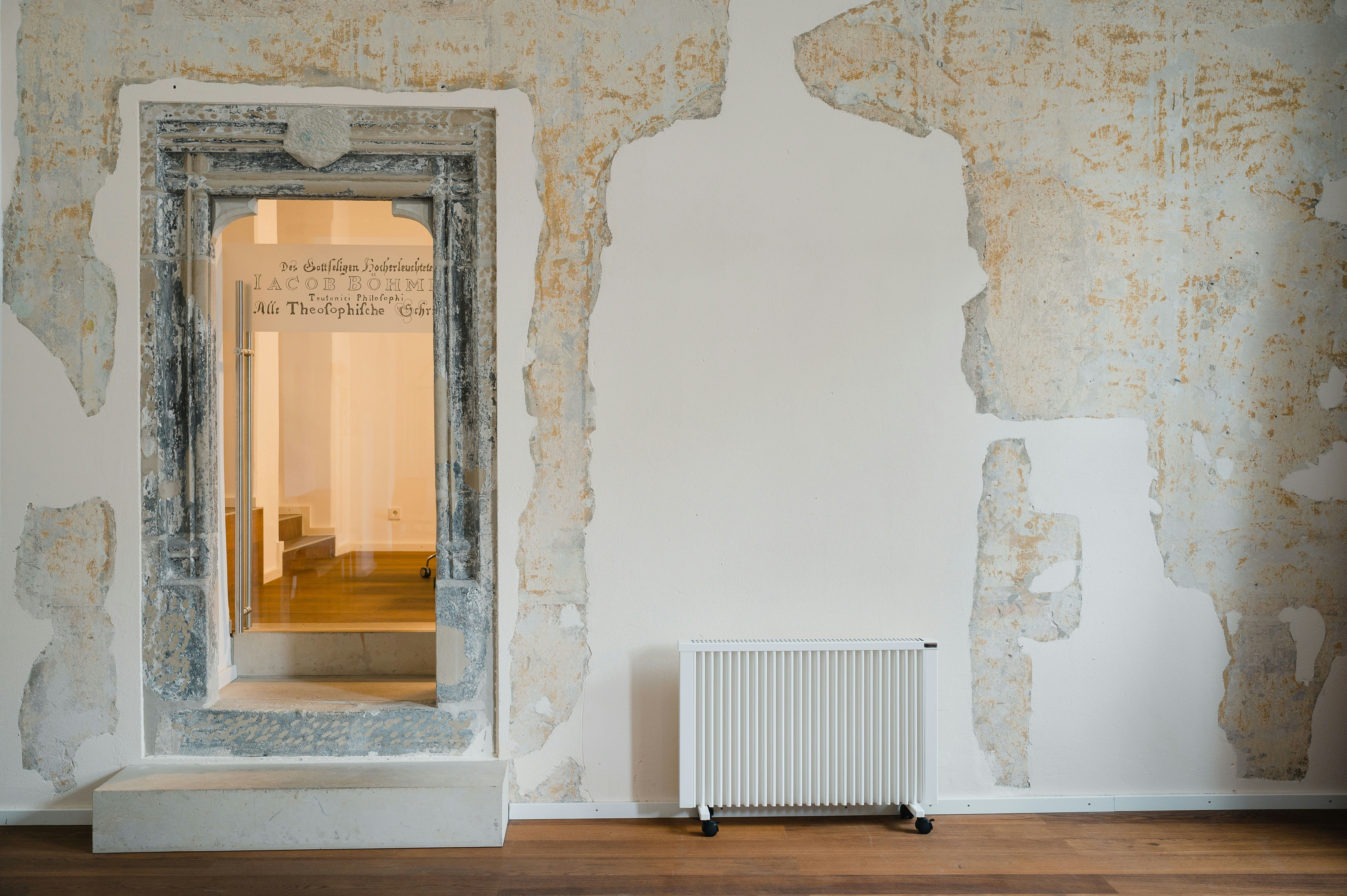 Weathered wall with antique doorway leading to wooden stairs