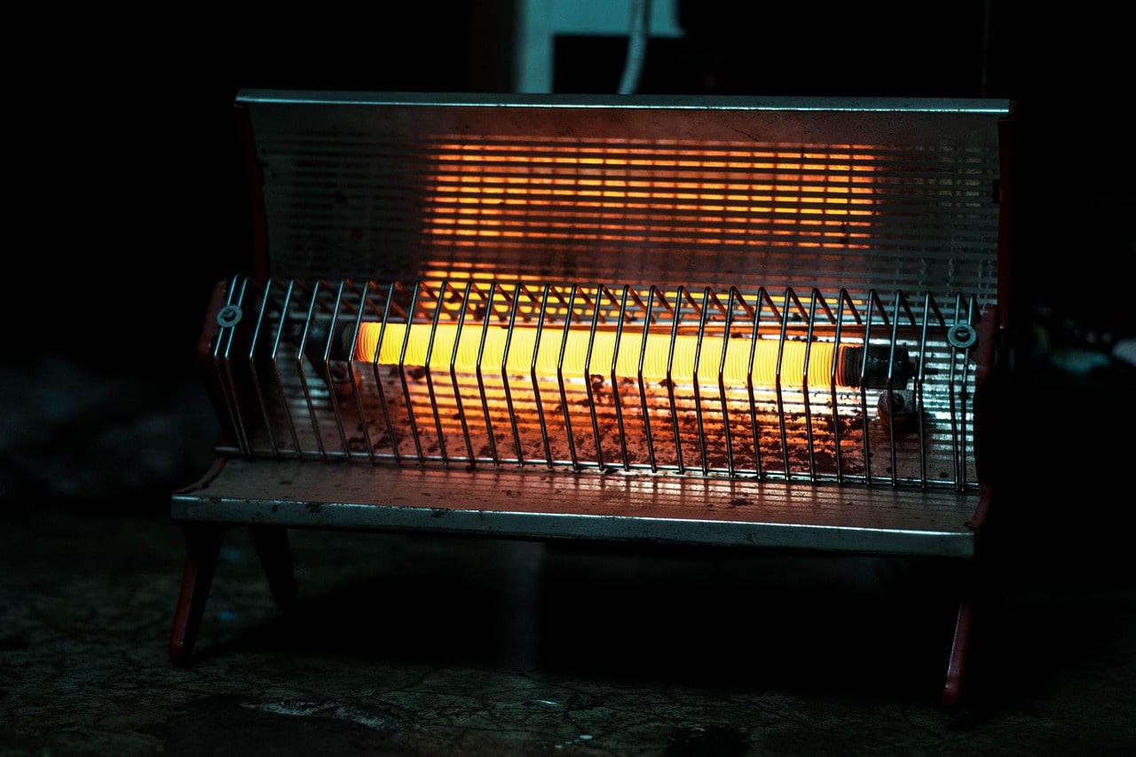 Electric heater glowing with warm orange light in a dark room