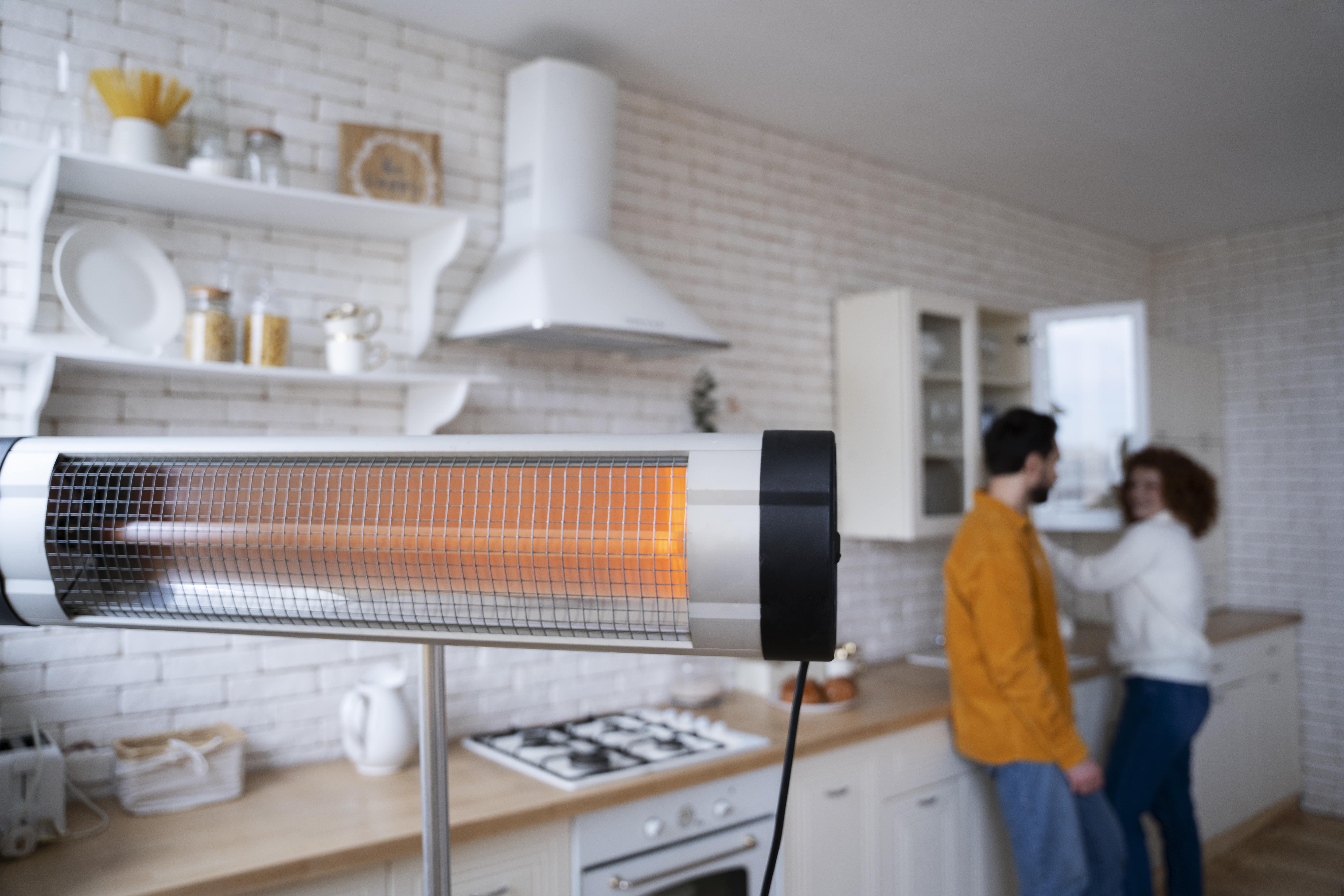 Electric heater glowing orange in modern white kitchen with people