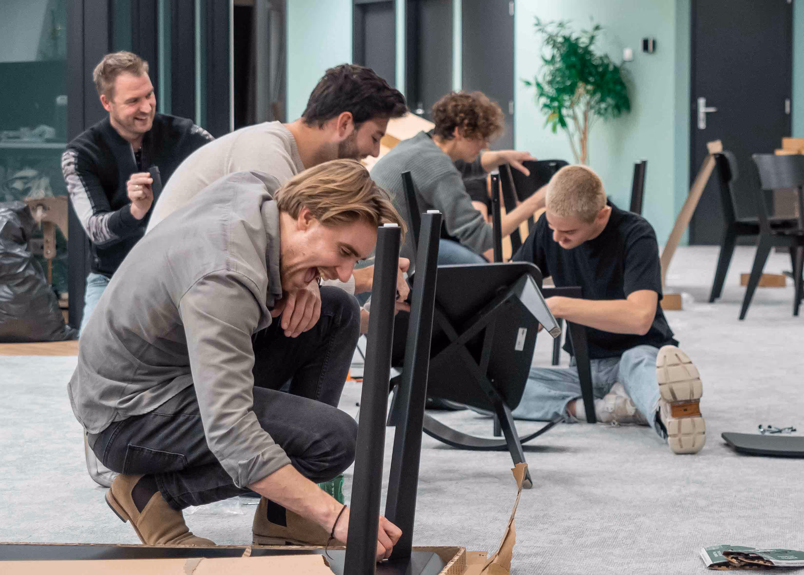 Manometric employees assembling furniture together in the office.