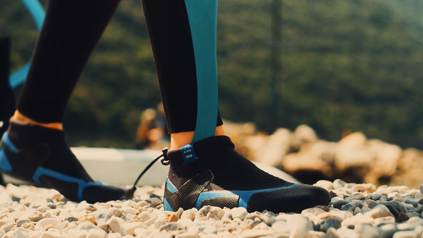 Close-up of a person wearing a Manometric ankle foot orthosis on a rocky beach.