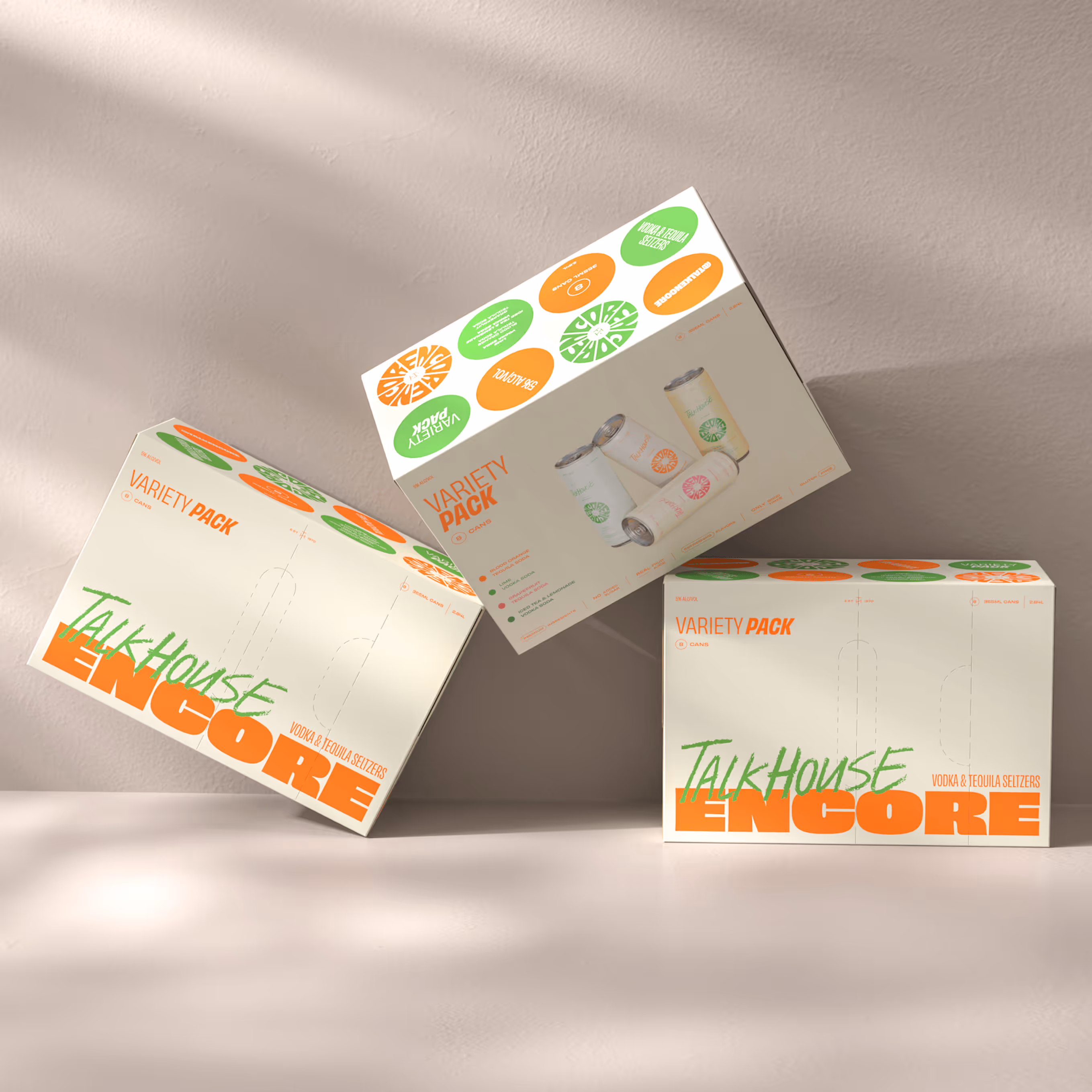 Three TalkHouse Encore variety pack boxes of vodka and tequila seltzers, displayed at different angles on a light surface against a beige wall.