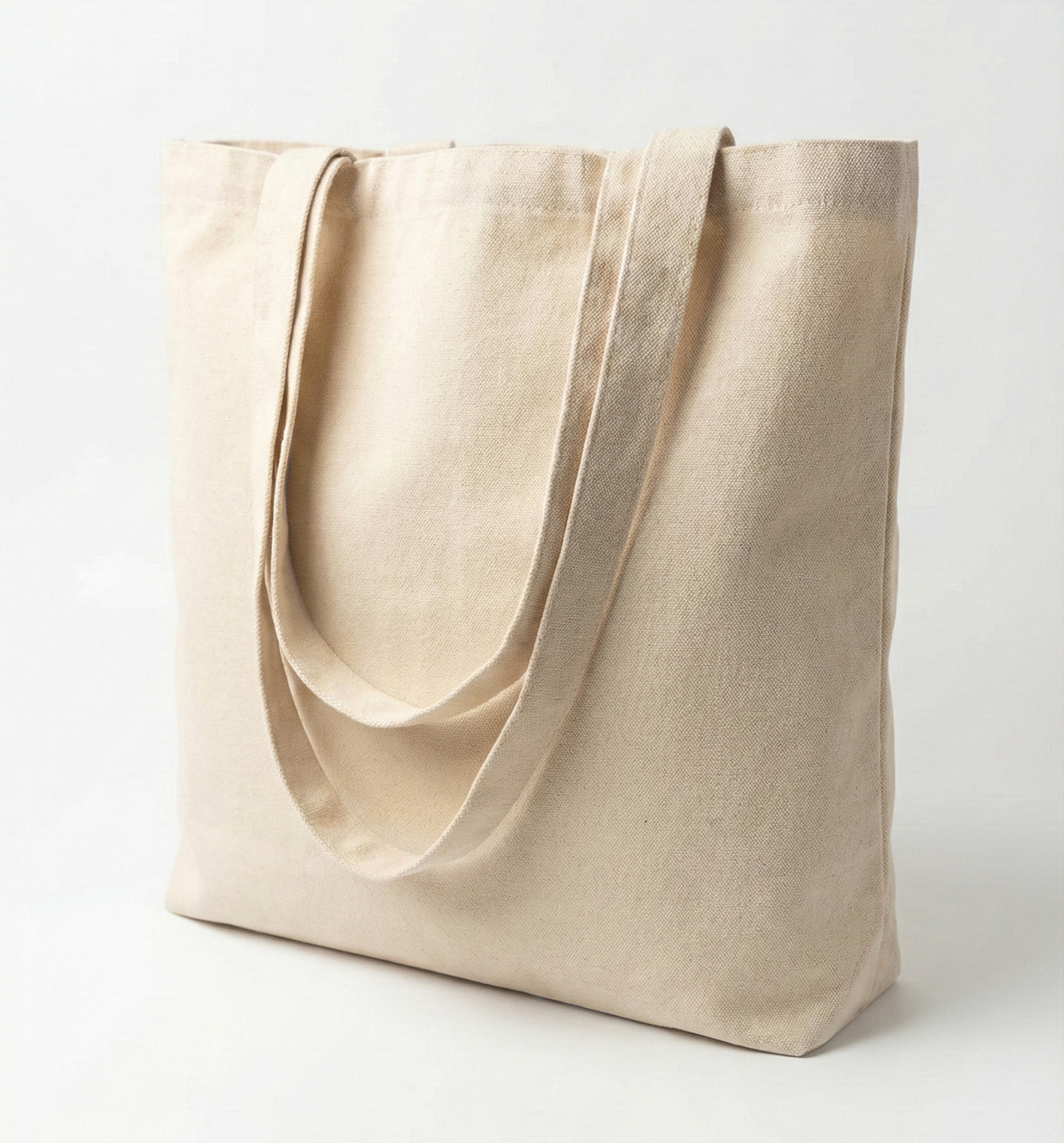 Plain beige canvas tote bag with long handles on a white background.