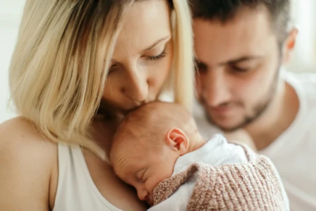 Parents cradling their newborn baby