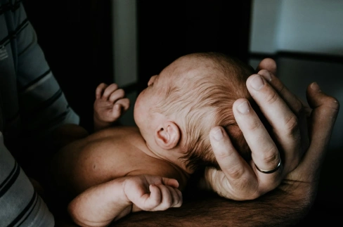 Parents holding their newborn baby symbolizing healthy family planning with genetic testing