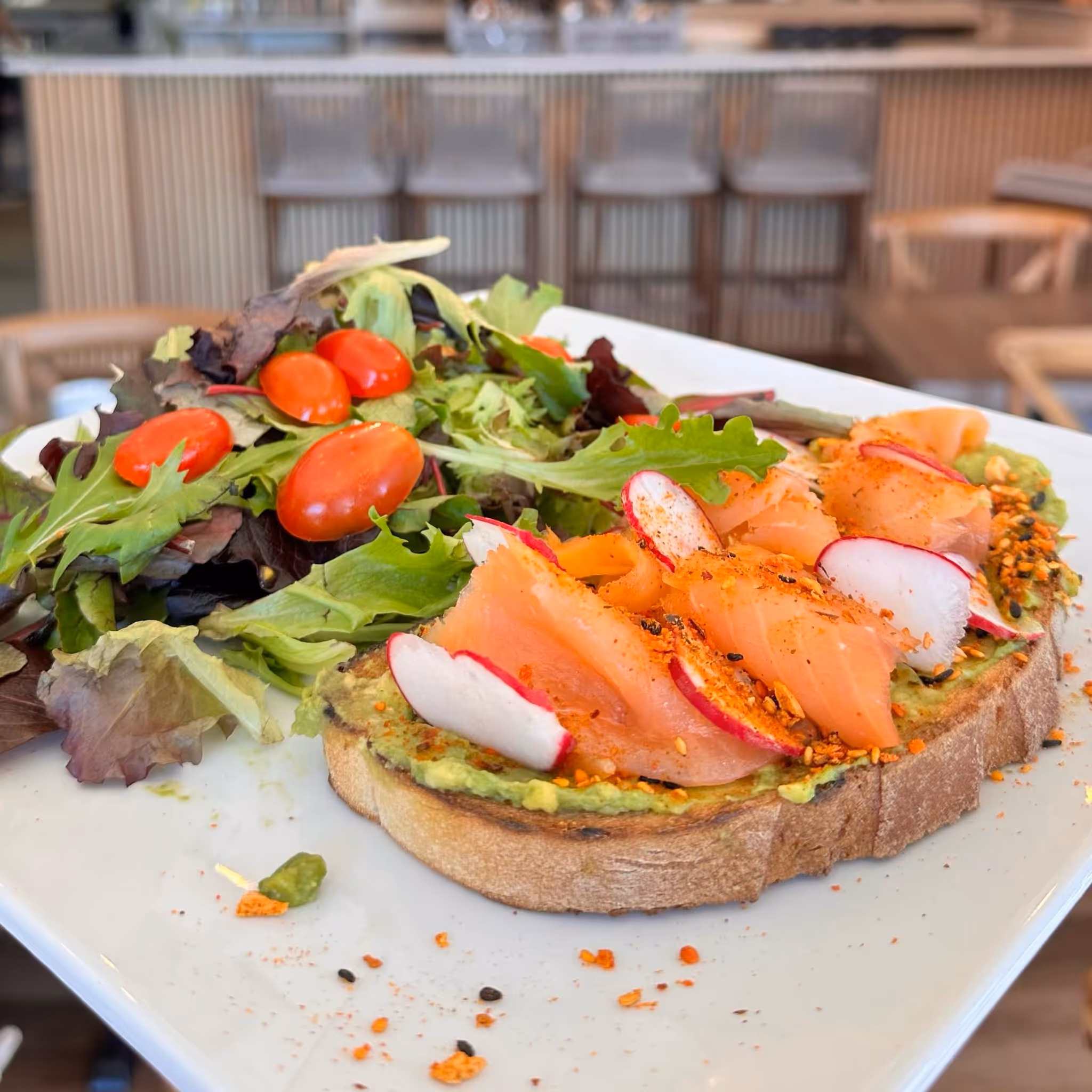 A plate of food with a sandwich, salad, and tomatoes.