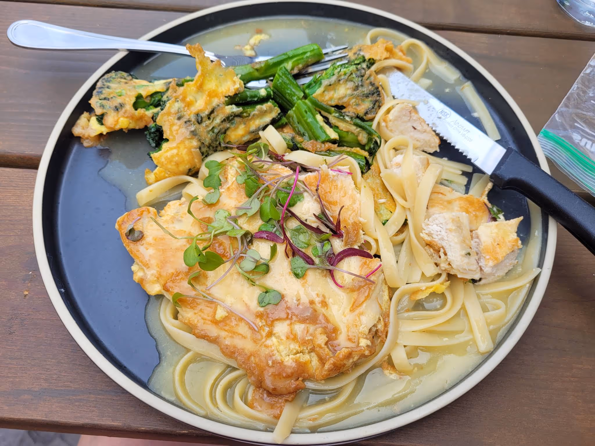 A plate of food with noodles, chicken, and vegetables.