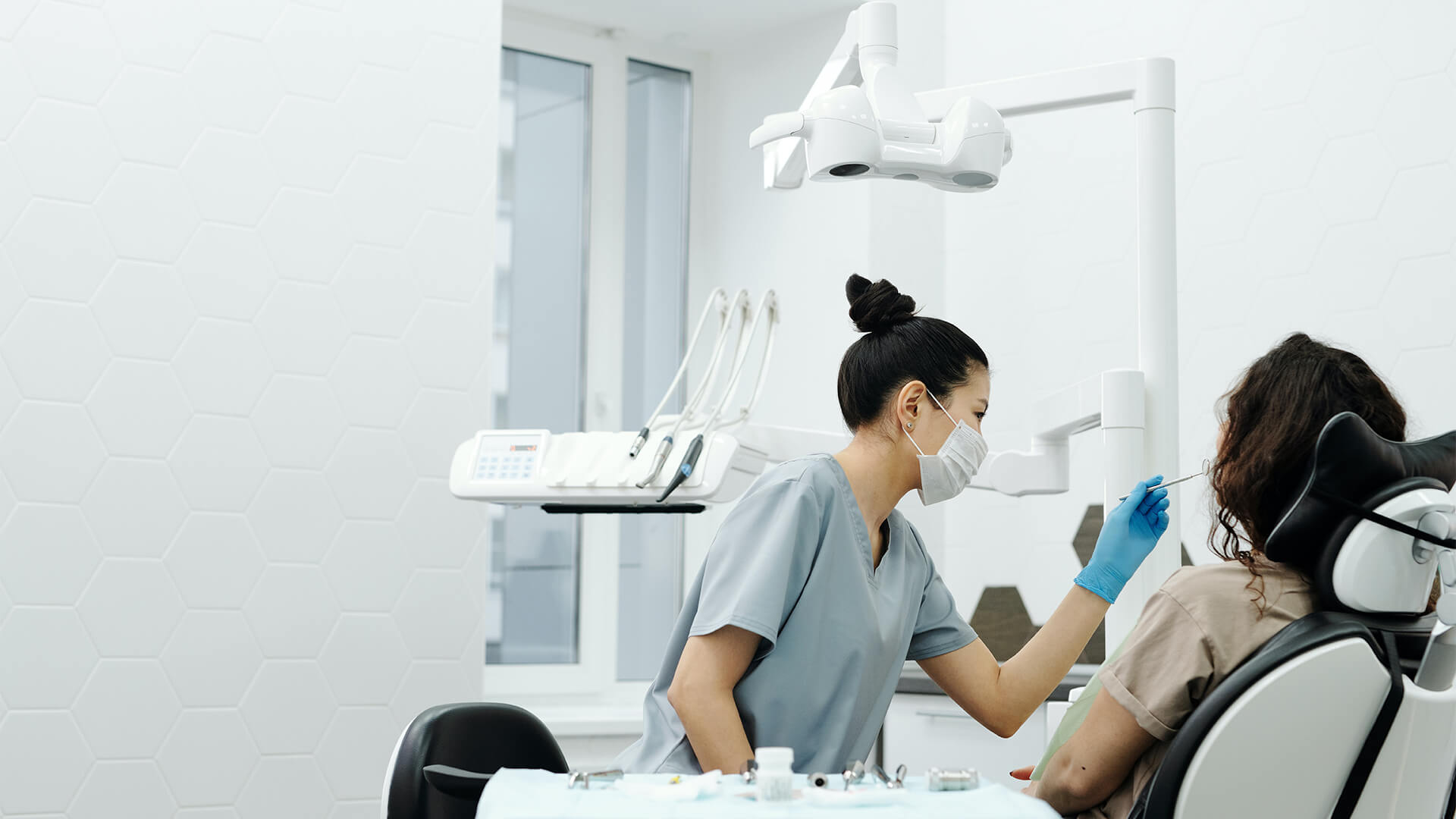 A woman getting her teeth checked by a dentist.