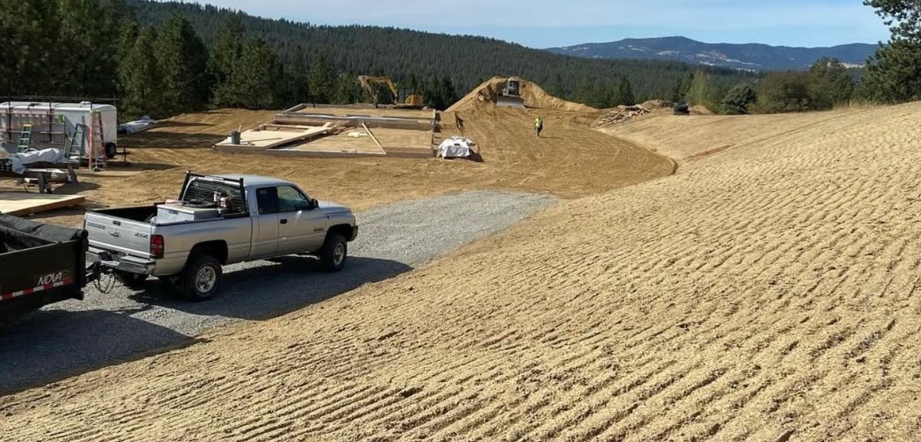 Graded gravel access area with pickup trucks on a North Idaho site