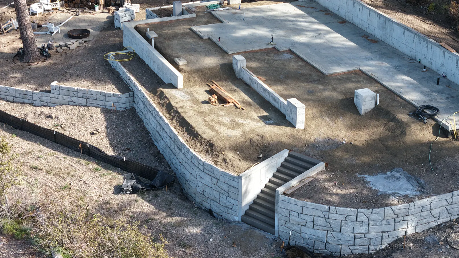 Tiered block retaining walls and stairs built by IVR Earthworks on a lakefront home site in North Idaho