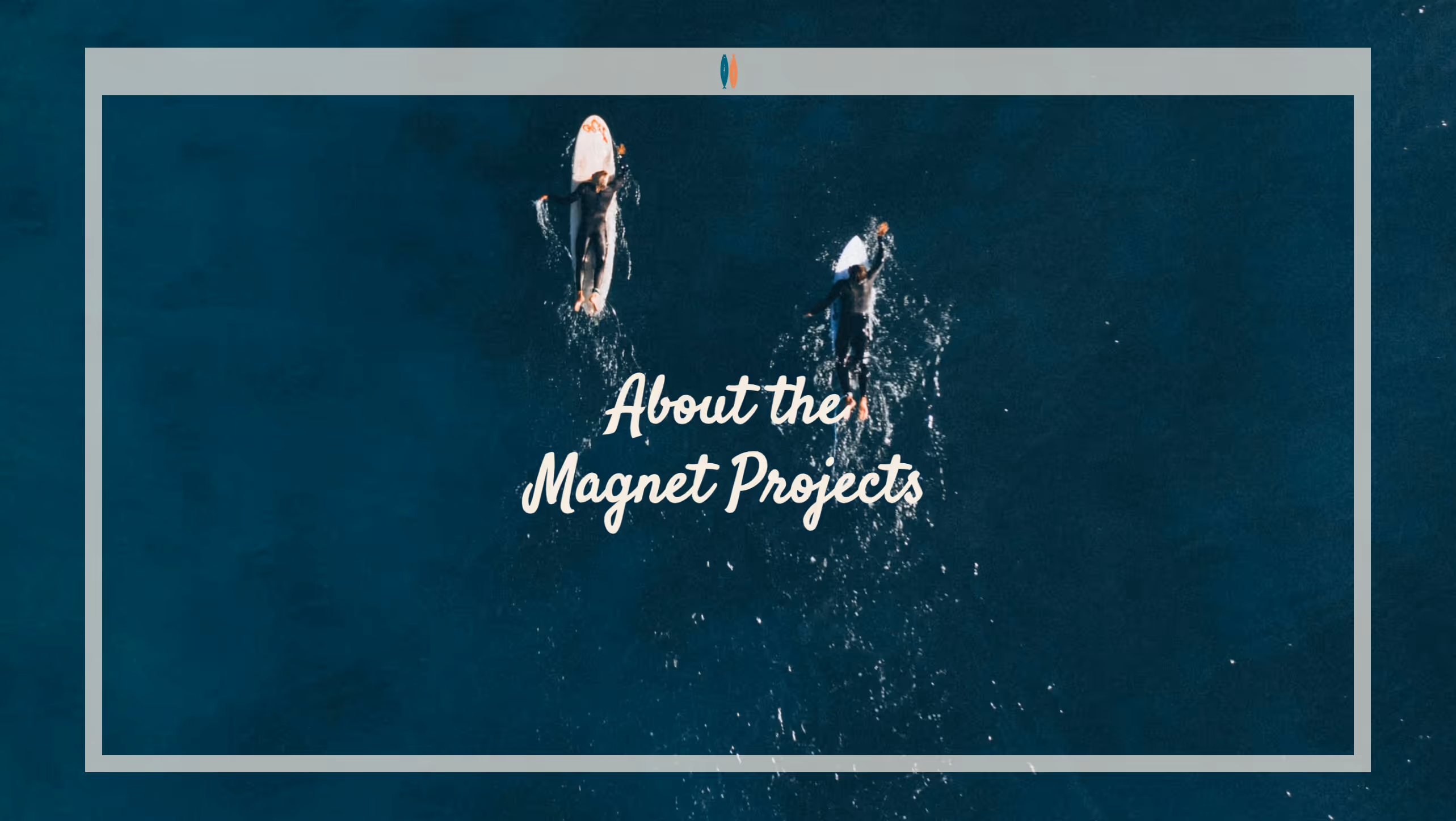 Two surfers paddling on surfboards in dark blue ocean water viewed from above.