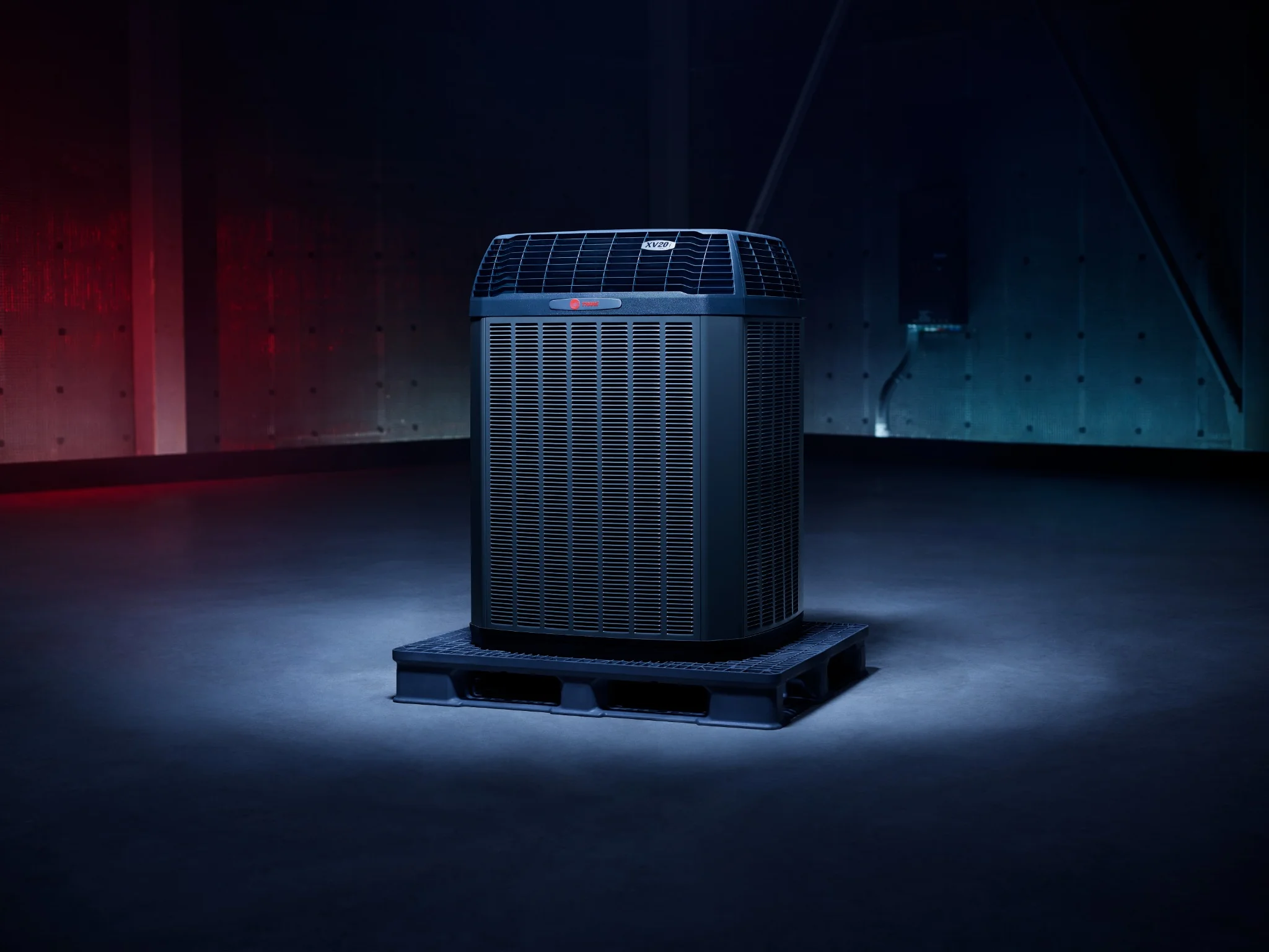 Trane XV20i high-efficiency HVAC unit on a black pallet in a dimly lit industrial space.